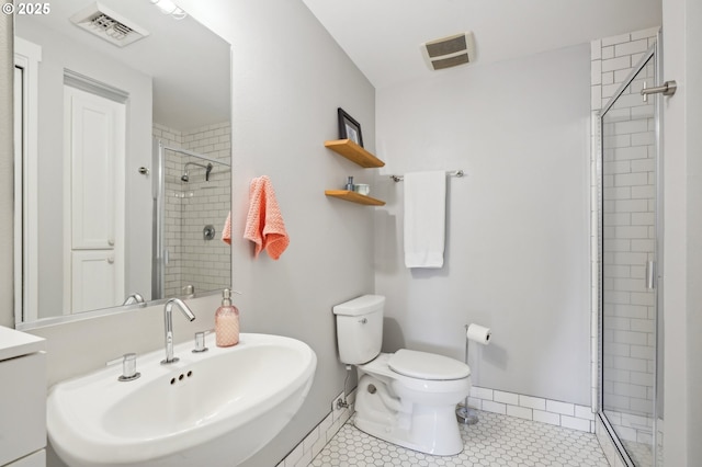 bathroom featuring visible vents, a stall shower, a sink, tile patterned floors, and toilet