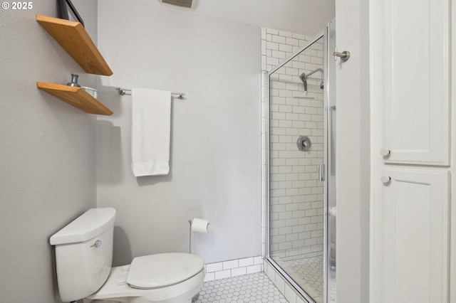 bathroom featuring tile patterned floors, a shower stall, and toilet