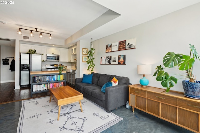 living room featuring track lighting, baseboards, and visible vents