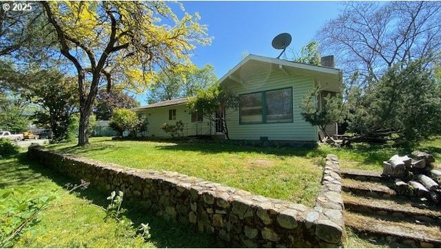 view of property exterior featuring a lawn and a chimney