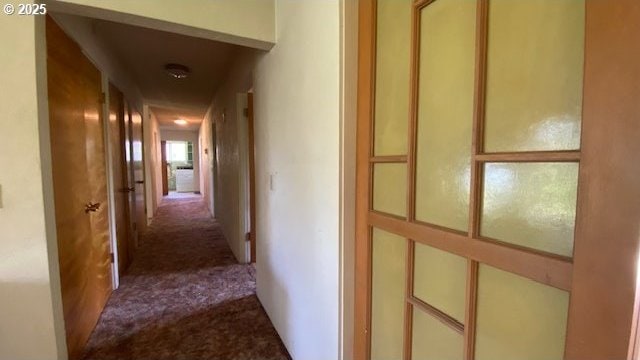corridor featuring dark colored carpet
