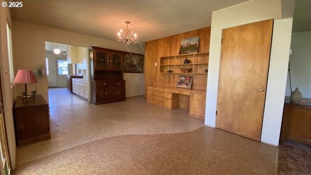 dining room with a notable chandelier, built in features, and speckled floor
