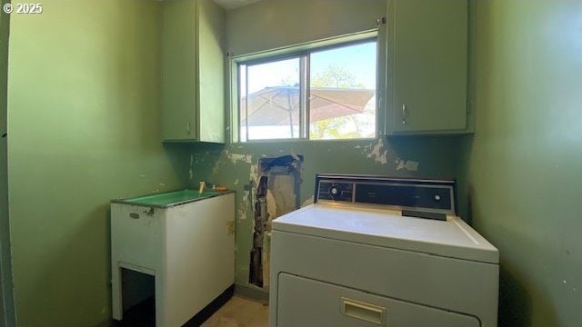 washroom featuring cabinet space and washer / clothes dryer
