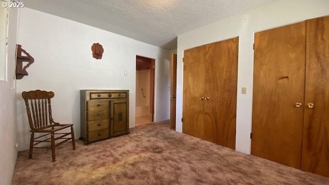 unfurnished bedroom featuring a textured ceiling, carpet, and two closets