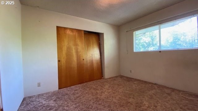 unfurnished bedroom featuring carpet floors and a closet