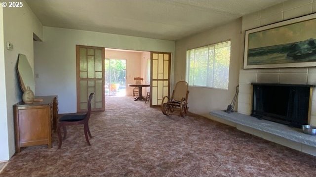 living area featuring carpet floors and a tile fireplace