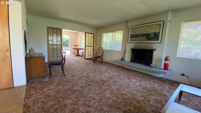 living room with carpet flooring, a wealth of natural light, and a fireplace