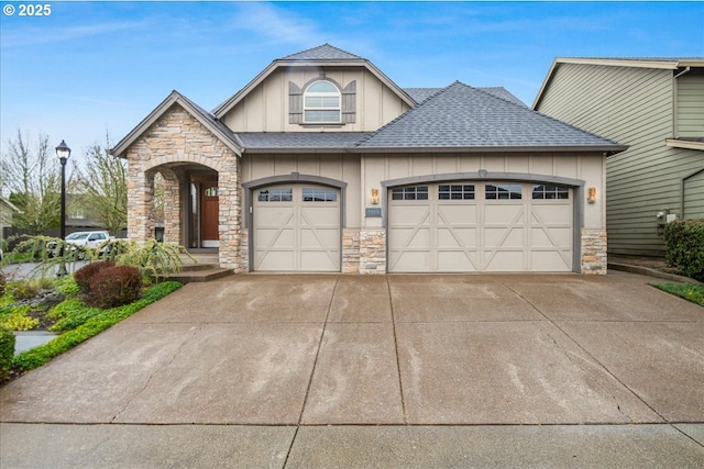 craftsman-style home featuring stone siding, an attached garage, concrete driveway, and a shingled roof