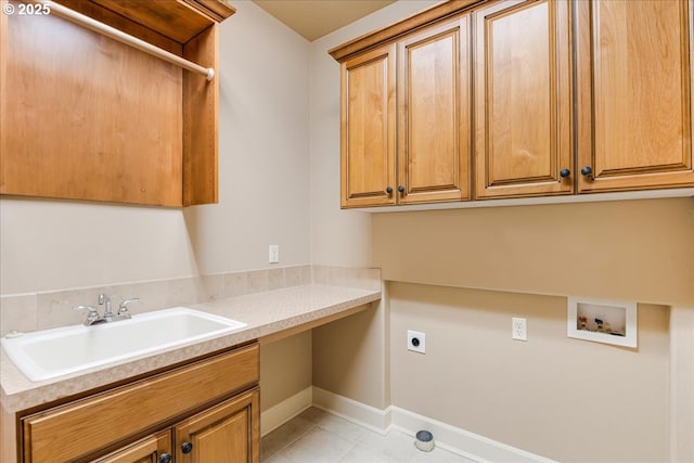 washroom with a sink, cabinet space, baseboards, hookup for an electric dryer, and hookup for a washing machine