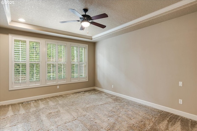 carpeted empty room featuring a textured ceiling, a tray ceiling, and a ceiling fan