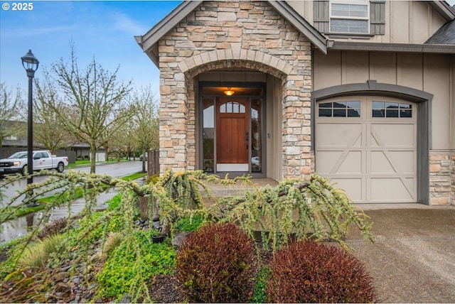 view of exterior entry with board and batten siding, an attached garage, and stone siding