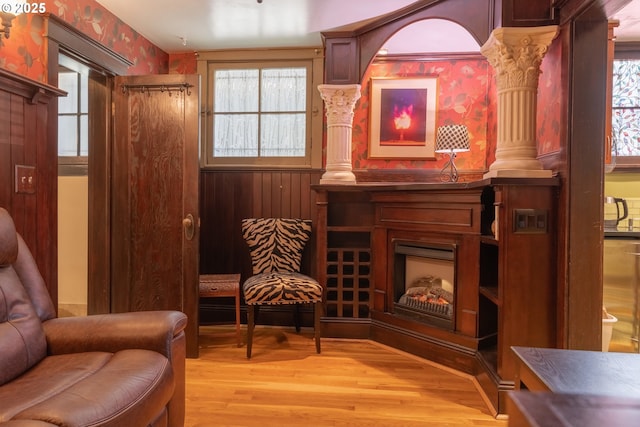 2046 NW Flanders St Unit 13-1, Portland, OR 97209 - sitting room featuring wallpapered walls, light wood-style flooring, and decorative columns