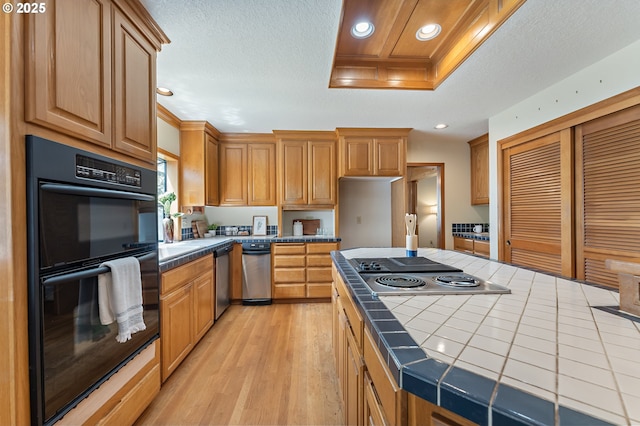 5844 Ridgetop Ct, Lake Oswego, OR 97035 - kitchen with tile counters, stainless steel appliances, light wood-type flooring, recessed lighting, and a kitchen island