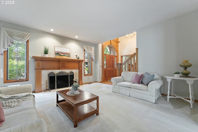 5844 Ridgetop Ct, Lake Oswego, OR 97035 - living room with light colored carpet, recessed lighting, a chandelier, stairway, and a tiled fireplace