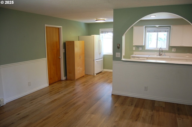 3024 Concord Way, Forest Grove, OR 97116 - kitchen with freestanding refrigerator, a sink, white cabinets, light countertops, and light wood-style flooring