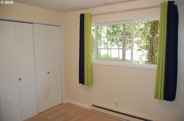 3024 Concord Way, Forest Grove, OR 97116 - unfurnished bedroom featuring a baseboard heating unit, carpet floors, a closet, a textured ceiling, and baseboards