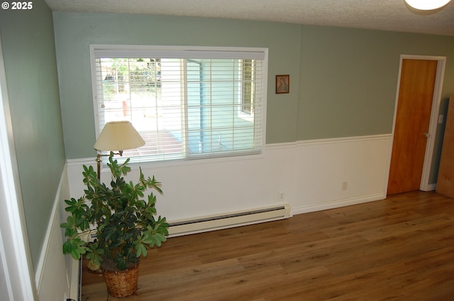 3024 Concord Way, Forest Grove, OR 97116 - unfurnished room featuring a baseboard heating unit, wood finished floors, and a textured ceiling