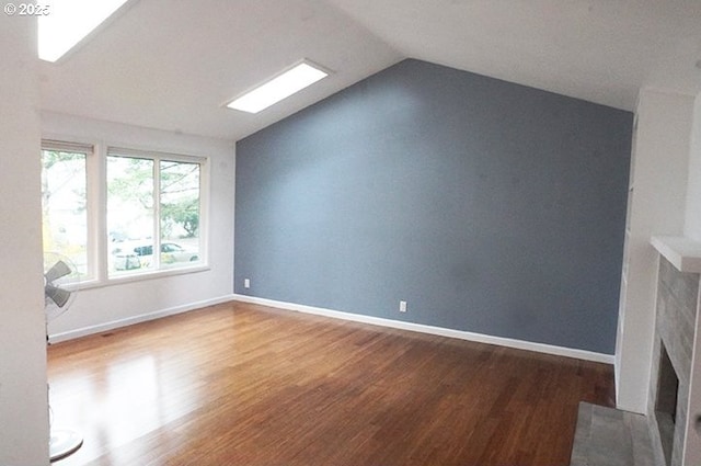 4768 Manzanita St, Eugene, OR 97405 - unfurnished living room featuring wood finished floors, lofted ceiling, a fireplace with flush hearth, and baseboards