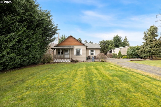 view of front facade with gravel driveway and a front lawn