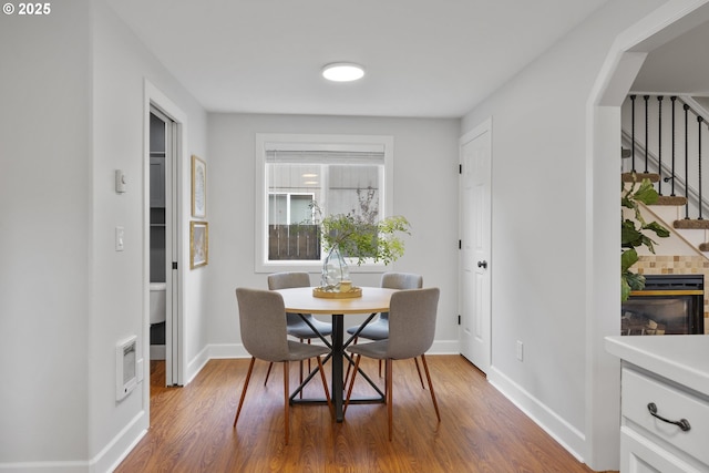 dining room featuring stairs, baseboards, and wood finished floors