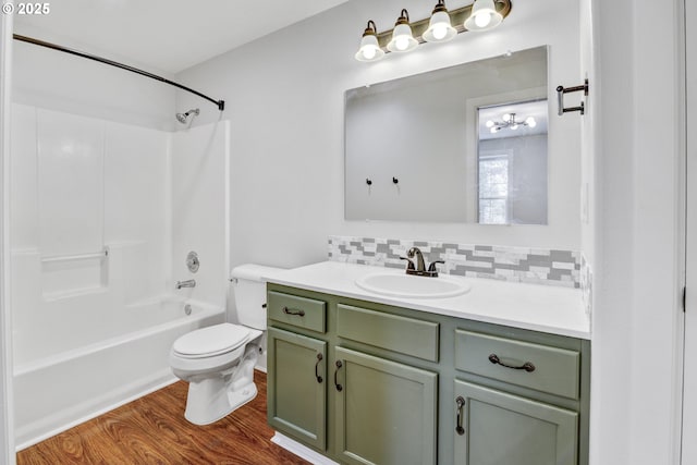 full bath featuring tasteful backsplash, shower / tub combination, wood finished floors, vanity, and toilet