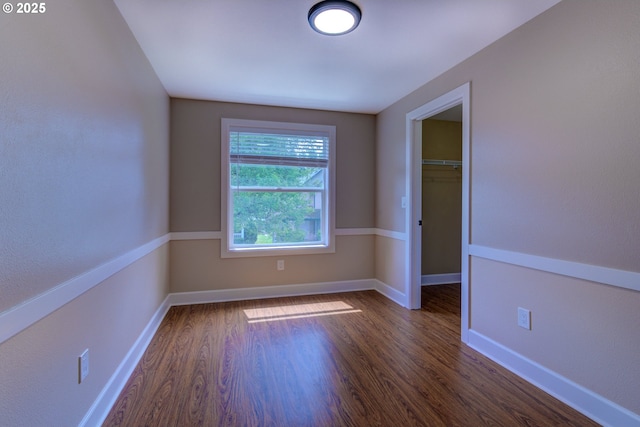 empty room featuring baseboards and wood finished floors