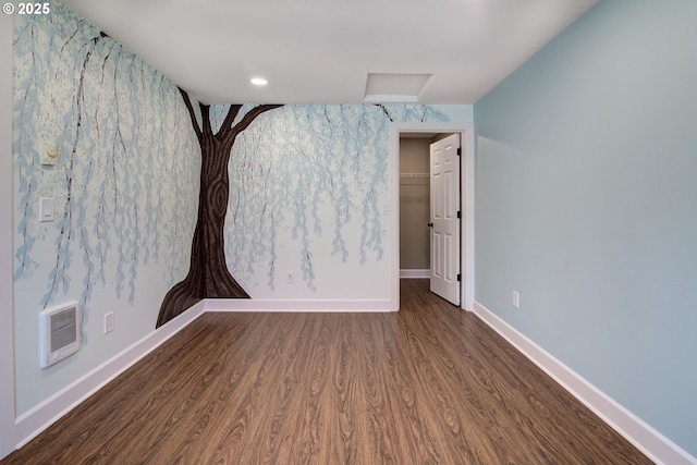 unfurnished room featuring baseboards, visible vents, and wood finished floors