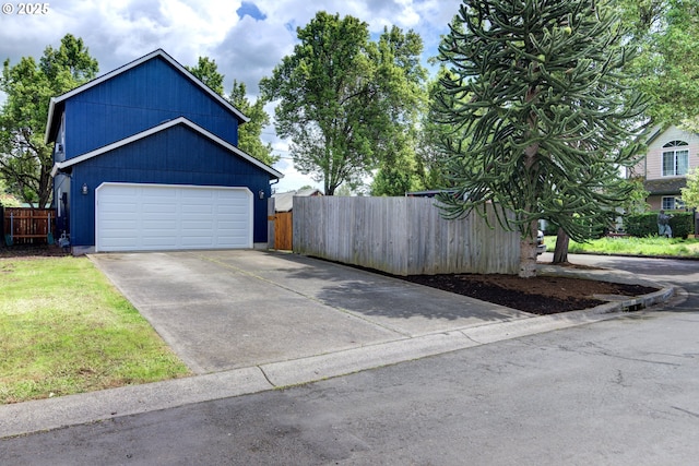 garage with fence and driveway