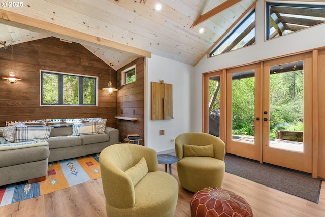 living room featuring wood walls, wood finished floors, french doors, high vaulted ceiling, and beam ceiling
