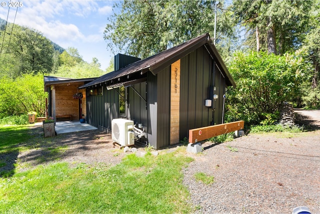 view of home's exterior featuring a cooling unit, a patio, and board and batten siding