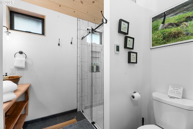 bathroom featuring a stall shower, toilet, tile patterned floors, vanity, and baseboards