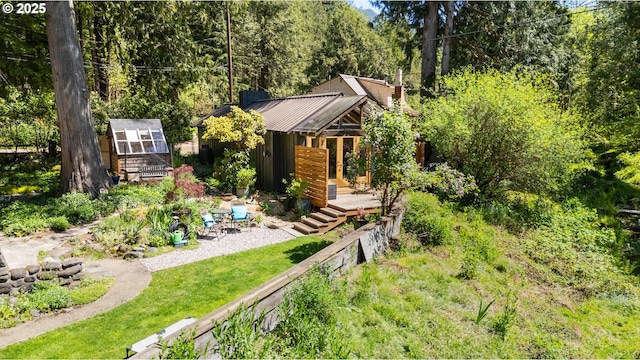 view of yard with an outbuilding and a wooded view
