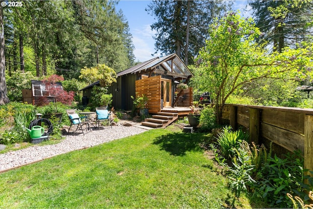 view of yard featuring an outdoor structure, a deck, and a patio