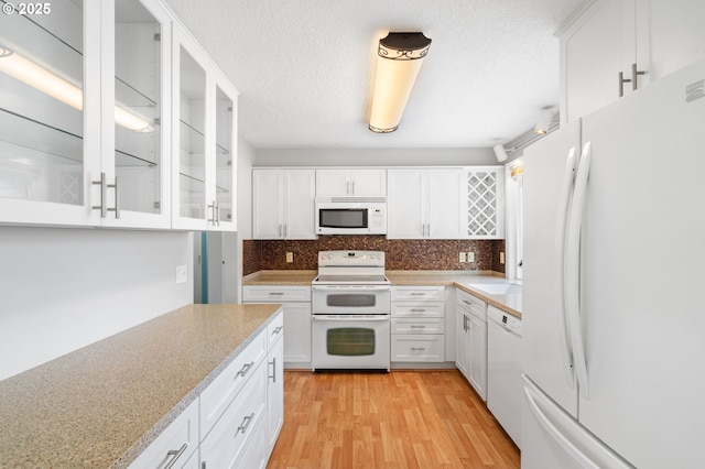 5016 SW Normandy Pl, Beaverton, OR 97005 - kitchen featuring white appliances, light wood finished floors, white cabinets, tasteful backsplash, and glass insert cabinets