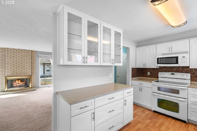 5016 SW Normandy Pl, Beaverton, OR 97005 - kitchen featuring white appliances, a textured ceiling, glass insert cabinets, white cabinetry, and backsplash