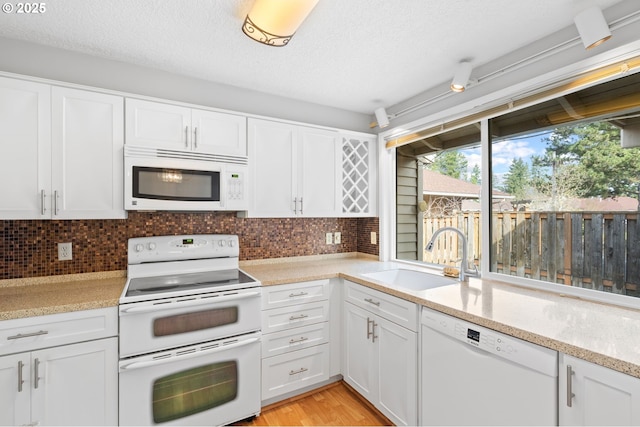 5016 SW Normandy Pl, Beaverton, OR 97005 - kitchen featuring white appliances, a sink, healthy amount of natural light, white cabinetry, and a textured ceiling