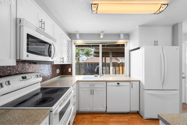5016 SW Normandy Pl, Beaverton, OR 97005 - kitchen with white appliances, light wood-style floors, a sink, backsplash, and white cabinets