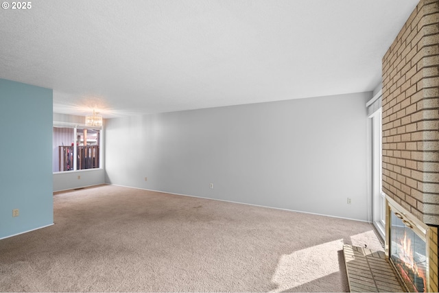 5016 SW Normandy Pl, Beaverton, OR 97005 - unfurnished living room with a brick fireplace, carpet floors, a chandelier, brick wall, and baseboards