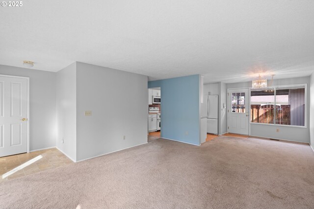 5016 SW Normandy Pl, Beaverton, OR 97005 - unfurnished living room featuring a chandelier, light carpet, and baseboards