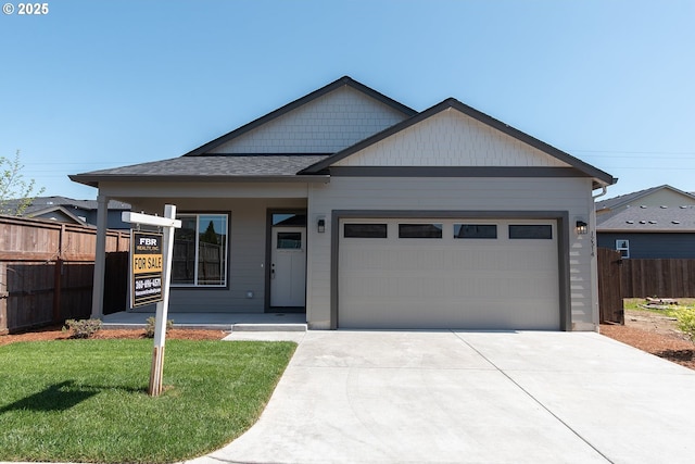 craftsman inspired home featuring a garage, stone siding, concrete driveway, and fence
