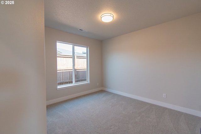 unfurnished room featuring a textured ceiling, visible vents, light carpet, and baseboards