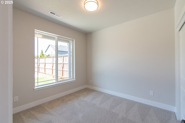 unfurnished room with baseboards, visible vents, carpet flooring, and plenty of natural light