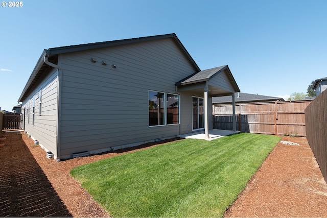 back of house featuring a yard, a fenced backyard, and a patio area