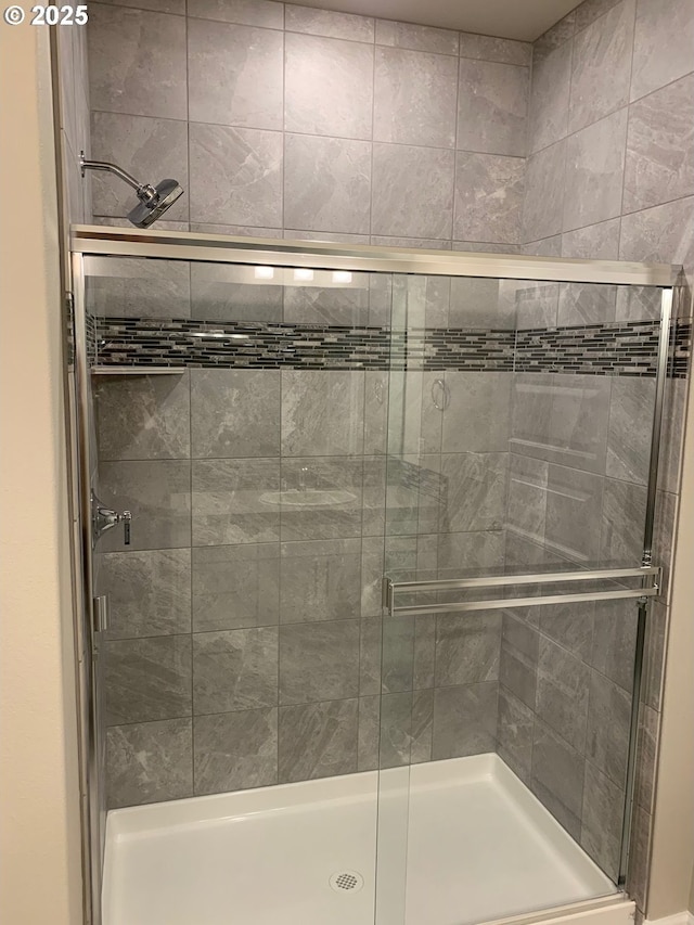 bathroom featuring a shower with door