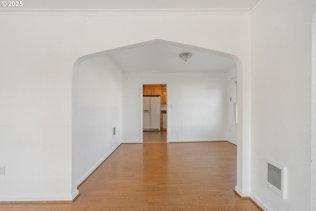 1108 4th St, Tillamook, OR 97141 - empty room with arched walkways, light wood finished floors, and crown molding