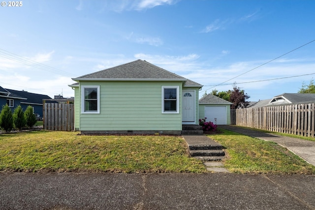1108 4th St, Tillamook, OR 97141 - view of front facade with an outbuilding, a detached garage, a shingled roof, and driveway