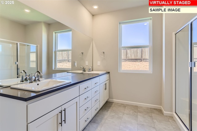 bathroom featuring baseboards, a sink, a shower stall, double vanity, and recessed lighting