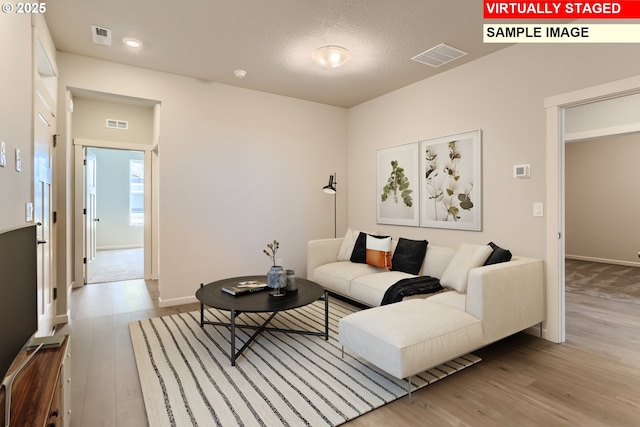 living area with recessed lighting, visible vents, baseboards, and wood finished floors