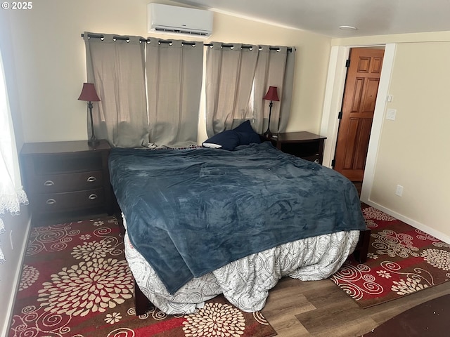 865 E Columbia River Hwy, Clatskanie, OR 97016 - bedroom featuring a wall unit AC, wood finished floors, and baseboards