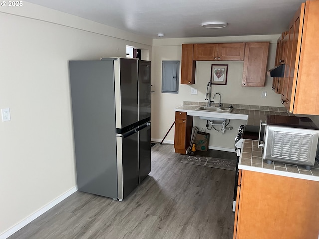 865 E Columbia River Hwy, Clatskanie, OR 97016 - kitchen featuring appliances with stainless steel finishes, brown cabinets, wood finished floors, and a sink